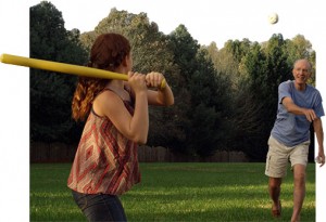 Father and daughter playing ball on a green lawn with trees in background after lawn service in Corinth