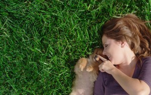 Pretty Woman playing with cute puppy on manicured green grass after Lawn Doctor provided Lawncare Service in Temple